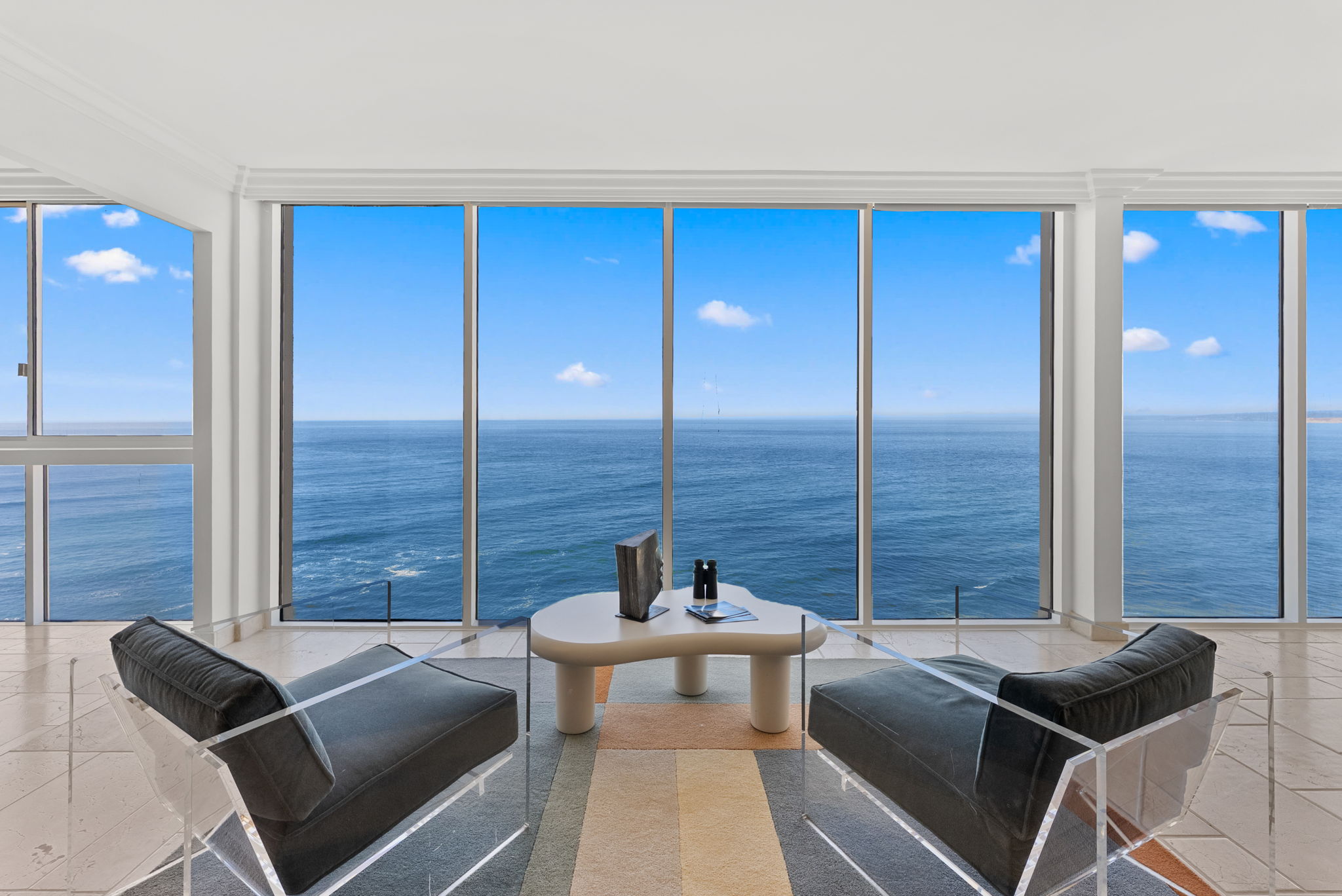 Oceanfront living room with floor-to-ceiling windows and panoramic ocean views — San Diego real estate photography by YonoPro