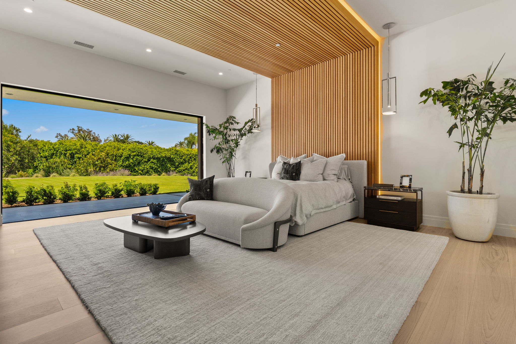 Primary bedroom with wood-slat accent wall opening to the garden — San Diego real estate photography by YonoPro